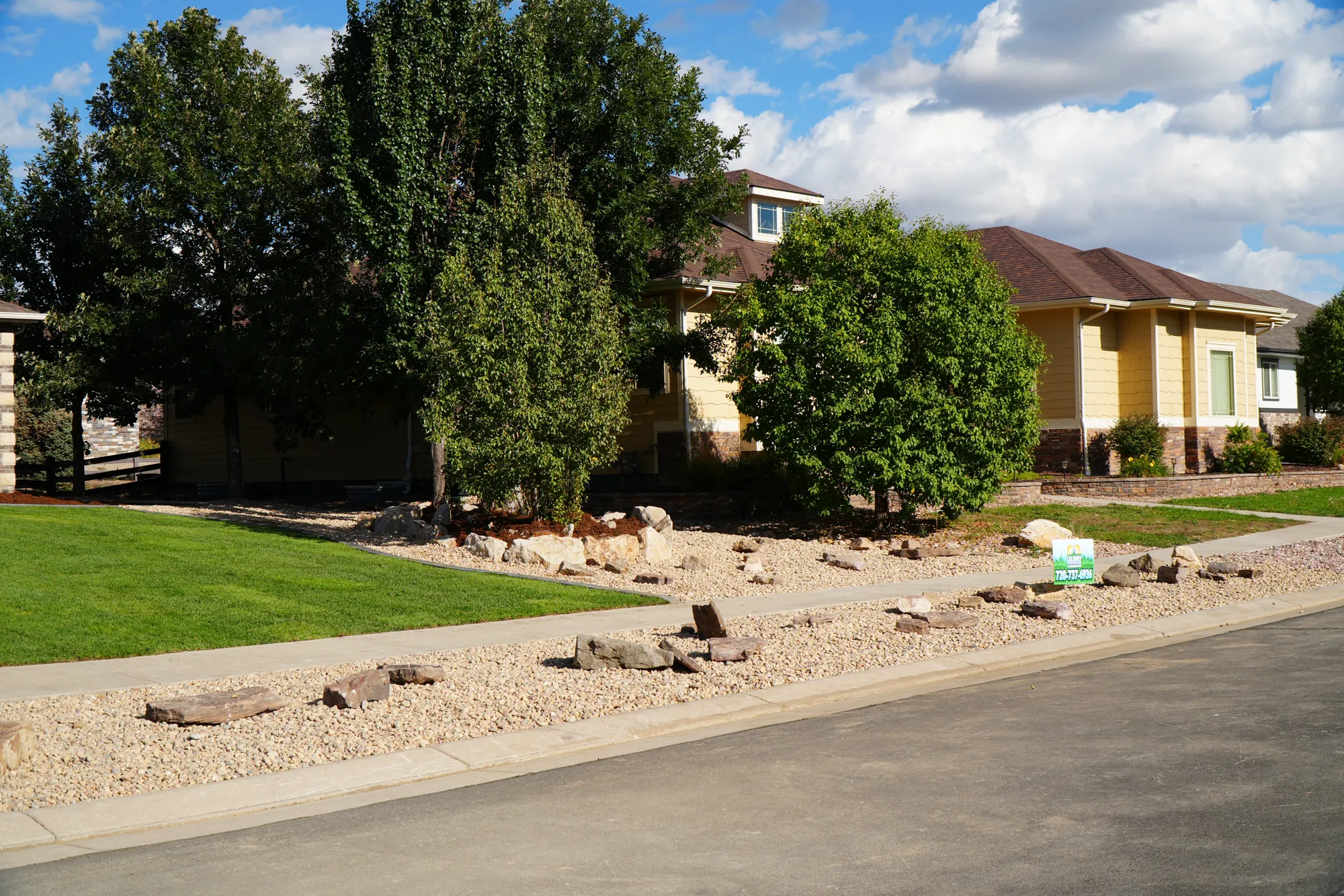 Front Yard: lawn, rock border and boulders across a full front yard